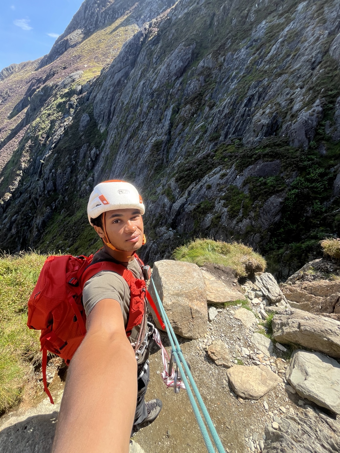 Climber wearing a helmet and red backpack during alpine training